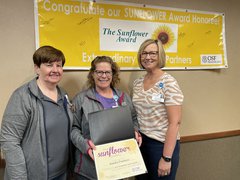 Congratulating Aundra Pacheco, 2022 Sunflower Award winner are Lori Christiansen, vice president of Support Services (left), and Jackie Kernan, OSF Saint Luke president (right)