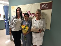 Photo of Jean Sumortin, accepting her Sunflower Award from (L) Stacy Neill, the patient’s mother who nominated her, and (R) Joanne Leigh, Director of Laboratory Services.